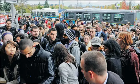  ?? LES BAZSO / PNG ?? Commuters are transferre­d to buses Friday after a homemade bomb was found on SkyTrain track near Surrey’s Gateway station.