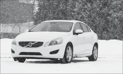  ?? PHOTOS: KEVIN MIO, THE GAZETTE ?? The 2013 Volvo S60 with optional all-wheel drive has no problem handling snowy Montreal roads. But keeping this white car clean during a storm is another story.