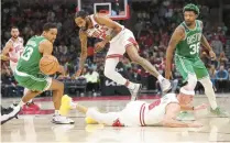  ?? ARMANDO L. SANCHEZ/CHICAGO TRIBUNE ?? The Celtics’ Malcolm Brogdon (13) and Marcus Smart (36) and the Bulls’ Derrick Jones Jr. (5) and Alex Caruso (6) chase a loose ball Oct. 24 at the United Center.