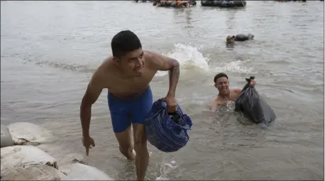  ??  ?? Central American migrants reach the shore on the Mexican side of the Suchiate River after wading across, on the the border between Guatemala and Mexico, in Ciudad Hidalgo, Mexico, on Saturday.AP PHOTO/ MOISES CASTILLO