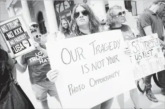  ?? JOHN MINCHILLO THE ASSOCIATED PRESS ?? Protesters against a scheduled visit from U.S. President Donald Trump holds signs outside city hall Tuesday in Dayton, Ohio. Trump was planning to visit both Dayton and El Paso, Texas, on Wednesday.