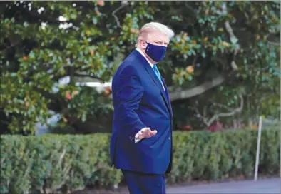  ?? The Associated Press ?? President Donald Trump waves to the press as he leaves the White House on Friday in Washington for Walter Reed National Military Medical Center after he tested positive for COVID-19.