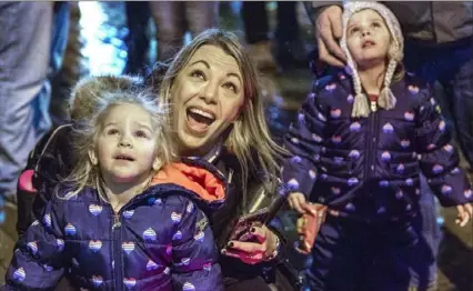 ?? Christian Snyder/Post-Gazette ?? Brooklyn Woodruff, 2, left, and her twin sister, Brianna, look up at the fireworks with their mother, Lisa Woodruff, all of Finleyvill­e, during Pittsburgh’s annual First Night celebratio­n Tuesday Downtown.