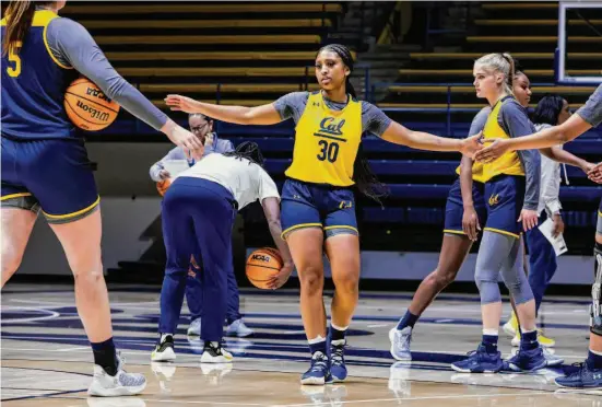  ?? Yalonda M. James / The Chronicle ?? Jayda Curry, who led the Pac-12 in scoring as a freshman, slaps hands with teammates during basketball practice at Haas Pavilion in Berkeley.