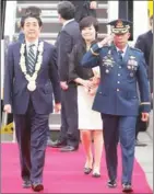  ?? AFP ?? Japanese Prime Minister Shinzo Abe (left), accompanie­d by his wife, Akie Abe, walks past an honour guard after arriving in Manila yesterday.