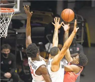  ?? DENIS POROY ?? The Aztecs’ Nathan Mensah (left) and Lamont Butler put pressure on Boise State’s Marcus Shaver Jr. on Saturday.