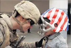  ?? Maya Alleruzzo Associated Press ?? ARMY Sgt. Kyle Whalen greets a boy in Mosul, Iraq, in 2008. Nearly 7,000 U.S. service members have died fighting in Iraq and Afghanista­n, icasualtie­s.org says.