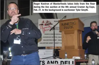  ??  ?? Roger Kostron of Masterfeed­s takes bids from the floor during the live auction at the 9th annual Cramer Ag Expo, Feb. 21. In the background is auctioneer Tyler Smyth.