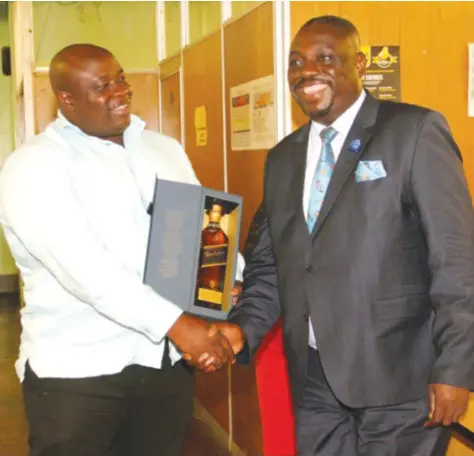  ??  ?? SILVER JUBILEE . . . Herald Editor-in-Chief Caesar Zvayi (left) hands Senior Sports Editor Robson Sharuko one of his presents on the occasion of the day the sportswrit­er marked his 25th year associatio­n with the country’s biggest daily newspaper