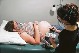  ?? Jerry Lara / Staff photograph­er ?? During a prenatal care visit last year, nurse midwife Annie Leone listens to the heartbeat of Melissa Woodfin’s child at the Holy Family Birth Center in Weslaco.