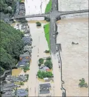  ?? AP ?? Partially submerged houses are seen along Kuma River that overflowed following heavy rain in Yatsushiro, Kumamoto..