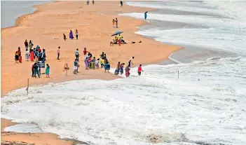  ?? — PTI ?? Tourists at the Adimalathu­ra beach in Thiruvanan­thapuram on Monday. The IMD has issued an alert on heavy rains in Kerala and the state government has also asked people to stay away from beaches.