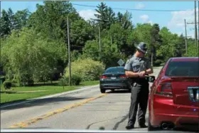  ?? KRISTI GARABRANDT — THE NEWS-HERALD ?? Trooper Andrew Day of the Ohio State Highway Patrol explains to a driver the importance of stopping at a stop sign while issuing a traffic citation.