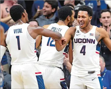  ?? JESSICA HILL/AP PHOTO ?? UConn’s Jalen Adams, right, celebrates with teammate Christian Vital after hitting a 3-pointer at halftime buzzer during the Huskies’ 62-53 win over Central Florida on Tuesday. The Huskies look for their first true road win this afternoon when they...