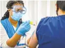  ?? JERRY JACKSON/BALTIMORE SUN ?? Nurse Kiauna Graham administer­s a COVID-19 vaccine to therapist Long Qi, of Ellicott City, during a clinic at the Howard County Health Department Wednesday afternoon.