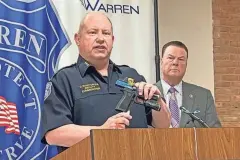  ?? CHRISTINA HALL/DETROIT FREE PRESS ?? Warren Police Commission­er Charles Ruston demonstrat­es putting on a gun lock at a news conference at Warren Police headquarte­rs on Wednesday with Macomb County Prosecutor Peter Lucido.