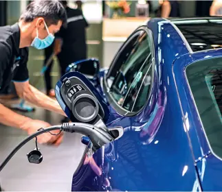  ??  ?? Electric vehicles and charging piles on display at the 2020 Shanghai Pudong Internatio­nal Automotive Exhibition held last October.