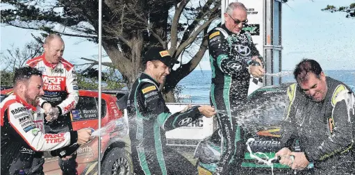  ?? PHOTO: GREGOR RICHARDSON ?? Top shots . . . Otago Rally competitor­s (from left) Josh Marston, Andrew Graves, Hayden Paddon, John Kennard and Regan Ross shower each other with sparkling wine on the podium at Brighton Domain yesterday.