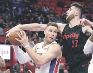  ?? AP ?? Jusuf Nurkic, de Portland, trata de evitar un canasto de Blake Griffin, de los Pistons, durante la primera mitad del partido de anoche en el baloncesto de la NBA.