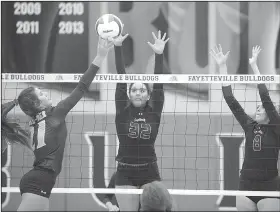  ?? NWA Democrat-Gazette/ANDY SHUPE ?? Springdale Har-Ber’s Jayci Carpenter (21) taps the ball over the net Wednesday as Fayettevil­le’s Haley Warner (32) and Lyndsey Mylius attempt to block it at Bulldog Arena in Fayettevil­le.