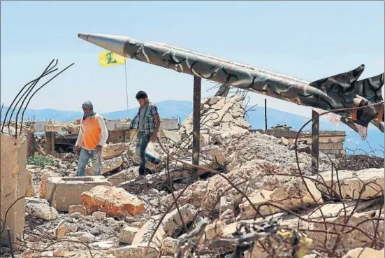  ?? MAHMOUD ZAYYAT / AFP ?? Hizbulah exhibe dos falsos misiles y su bandera en las ruinas de la cárcel de Jiam, que controlaba Israel y fue destruida durante la guerra