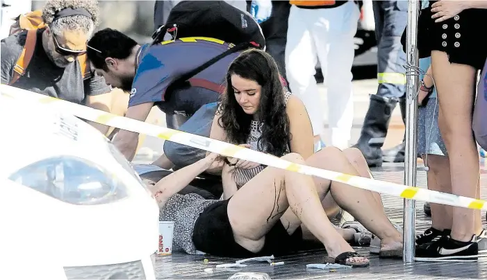  ?? Foto: AP ?? Hrůza Dívka utěšuje jednu ze zraněných po teroristic­kém útoku v centru Barcelony. Na dlažbě hlavní turistické třídy zůstaly ležet desítky obětí.