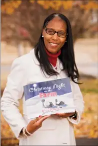  ?? EILISH PALMER/RIVER VALLEY & OZARK EDITION ?? Maria Hoskins of Mayflower holds a copy of Christmas Night on the
Farm, a book she self-published. She originally planned just to give a copy of the story to her mother, but Hoskins said her friend Patrick Oliver, founder of Say It Loud!, a...