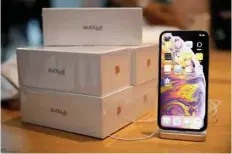  ?? — Reuters ?? Boxes of iphones purchased by customers are pictured next to an iphone XS on display at the Apple Store in Singapore.