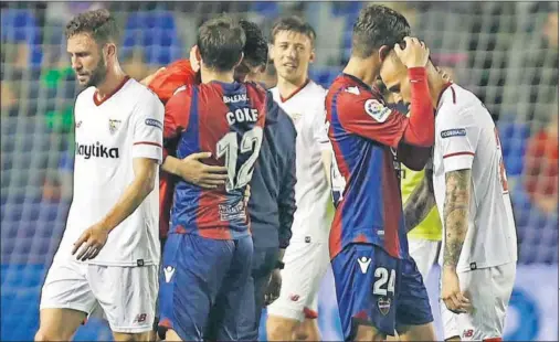  ??  ?? DECEPCIÓN SEVILLISTA. Campaña y Coke consuelan a los jugadores del Sevilla, tras la derrota cosechada en el Ciutat de Valencia.