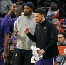  ?? AP photo ?? The Suns’ Devin Booker (right) and newly acquired Kevin Durant cheer from the bench during the second half Tuesday.
