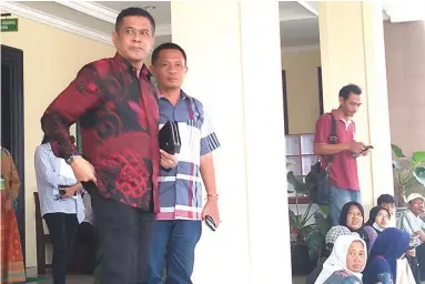  ?? CHRISTIAN DENNY/JAWA POS ?? KAWAL: Mantan Bupati Nganjuk Taufiqurra­hman (kiri) setelah menjalani sidang di Pengadilan Tipikor Surabaya di Sidoarjo kemarin.