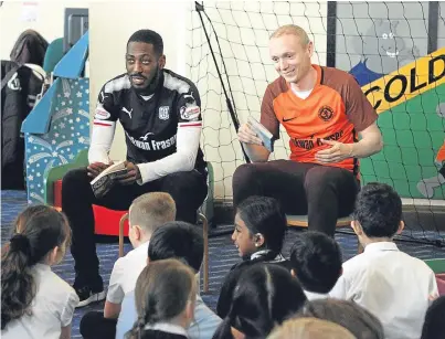  ?? Picture: Gareth Jennings. ?? Backing the initiative are players Roarie Deacon and Willo Flood who read to Dens Road Primary School pupils at Coldside Library in Dundee.