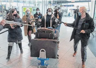  ?? RYAN REMIORZ THE CANADIAN PRESS ?? Media surround a passenger who arrived from Brussels Monday in Montreal. All travellers arriving from abroad will now have a mandatory three-day quarantine in a designated hotel.