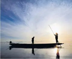  ?? KARNJANA KARNJANATA­WE ?? Men fish in Songkhla Lake at the break of dawn.