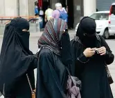  ??  ?? A Milano Tre donne islamiche passeggian­o in centro indossando il burqa