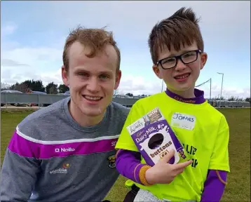  ??  ?? Wexford county hurling star Simon Donohoe presenting an Easter Egg to James Roche at the recent Easter Camp at Shelmalier­s GAA Club grounds.