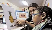  ?? ERALDO PERES/AP ?? Maria de Fatima Santos helps son Joaquim, 18 months, at school May 8 in Brazil. He was born with microcepha­ly.