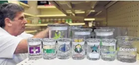  ?? KIM HAIRSTON/BALTIMORE SUN ?? Arnold Heckman stands near a display of custom jars his Elkridge company, Cannaline, supplies to the marijuana industry.