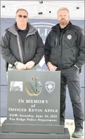  ?? https://tnebc.nwaonline.com/photos/. TIMES photograph by Annette Beard ?? Pea Ridge Police Chief Lynn Hahn and Officer Brian Stamps stand behind the replica of the monument planned for fallen Pea Ridge Police Officer Kevin Apple who was killed June 26, 2021, near the location of the memorial. Stamps was on duty with Apple during the incident which resulted in Apple’s death. For more photograph­s, go to the PRT gallery at