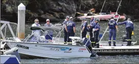  ?? MICK TSIKAS / AAP IMAGES ?? Fire & Rescue NSW personnel are seen at a boat ramp near Bobbin Head, New South Wales, on Tuesday. An accident investigat­or says the wreckage of a seaplane that crashed in a river north of Sydney will be raised this week.