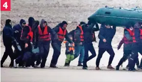  ?? ?? The determined migrants hoist the heavy green dinghy above