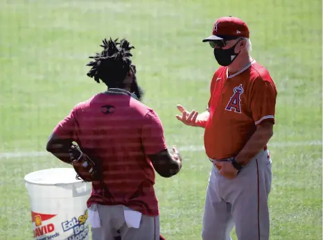  ?? SEAN M. HAFFEY / GETTY ?? Brian Goodwin talks with manager Joe Maddon during their summer workouts at Angel Stadium of Anaheim on July 3.