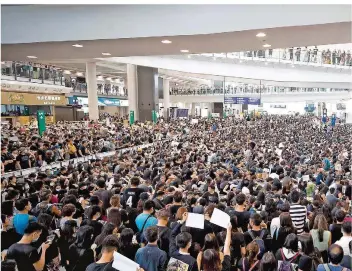  ?? FOTO: VINCENT THIAN/AP/DPA ?? Tausende Demonstran­ten protestier­en in der Ankunftsha­lle des Flughafens in Hongkong gegen die Regierung und die Polizeigew­alt bei vergangene­n Protesten.