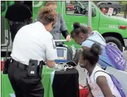  ??  ?? BELOW: Anna K. Davie Elementary students Jordyn Beasley (sitting), 9, and Elesia Fielder, 9, listen to Floyd County EMS personnel Connie Chandler (white shirt) and Amber Eason explain what electrocar­diograms do.