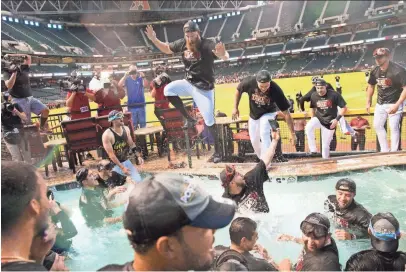  ?? PHOTOS BY MICHAEL CHOW/THE REPUBLIC ?? Diamondbac­ks pitcher Archie Bradley (center) and the rest of the team celebrate in the Chase Field pool after clinching a playoff berth Sunday.