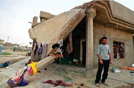  ?? AFP ?? Iraqi father-of-five Issa Al-Zamzoum stands outside his damaged house in the war-ravaged village of Habash, some 180 km north of Baghdad.