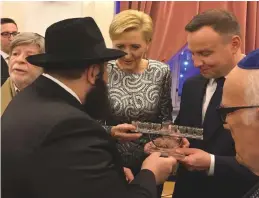  ?? (Ewa Szmal) ?? CHABAD EMISSARY Rabbi Szalom Ber Stambler presents President Andrzej Duda and his wife, Agata Kornhauser-Duda, with a menorah at a Hanukka event at the palace last Thursday.