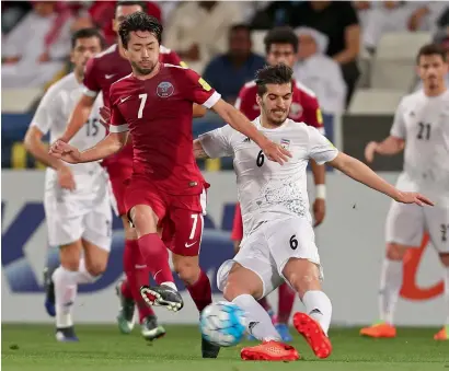  ?? AFP ?? Iran’s Saeid Ezatolahi (centre right), tackles Qatar’s Rodrigo Tabata during the World Cup 2018 Asia qualifying match. —