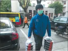  ?? CAI YANG / XINHUA ?? A volunteer delivers free packed meals to medical workers in Wuhan last month.