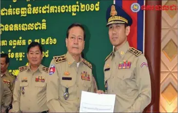  ?? NATIONAL POLICE ?? Hun Sen’s son-in-law Dy Vichea receives the letter promoting him to deputy National Police chief from National Police Commission­er Neth Savoeun in January.